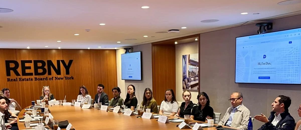 Dan AI breakfast event at REBNY, with retail leasing professionals seated around a conference table and Dan AI on the screens